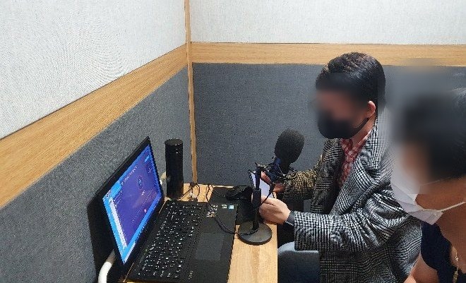 녹음 부스에서 전사 화면을 보며 발화하는 참여자